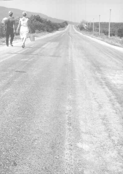 Picture: Couple carrying buckets on the road (21K JPEG 561x397)
